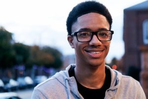 young man with glasses, smiling